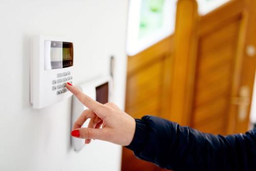 Young woman entering security code on keypad